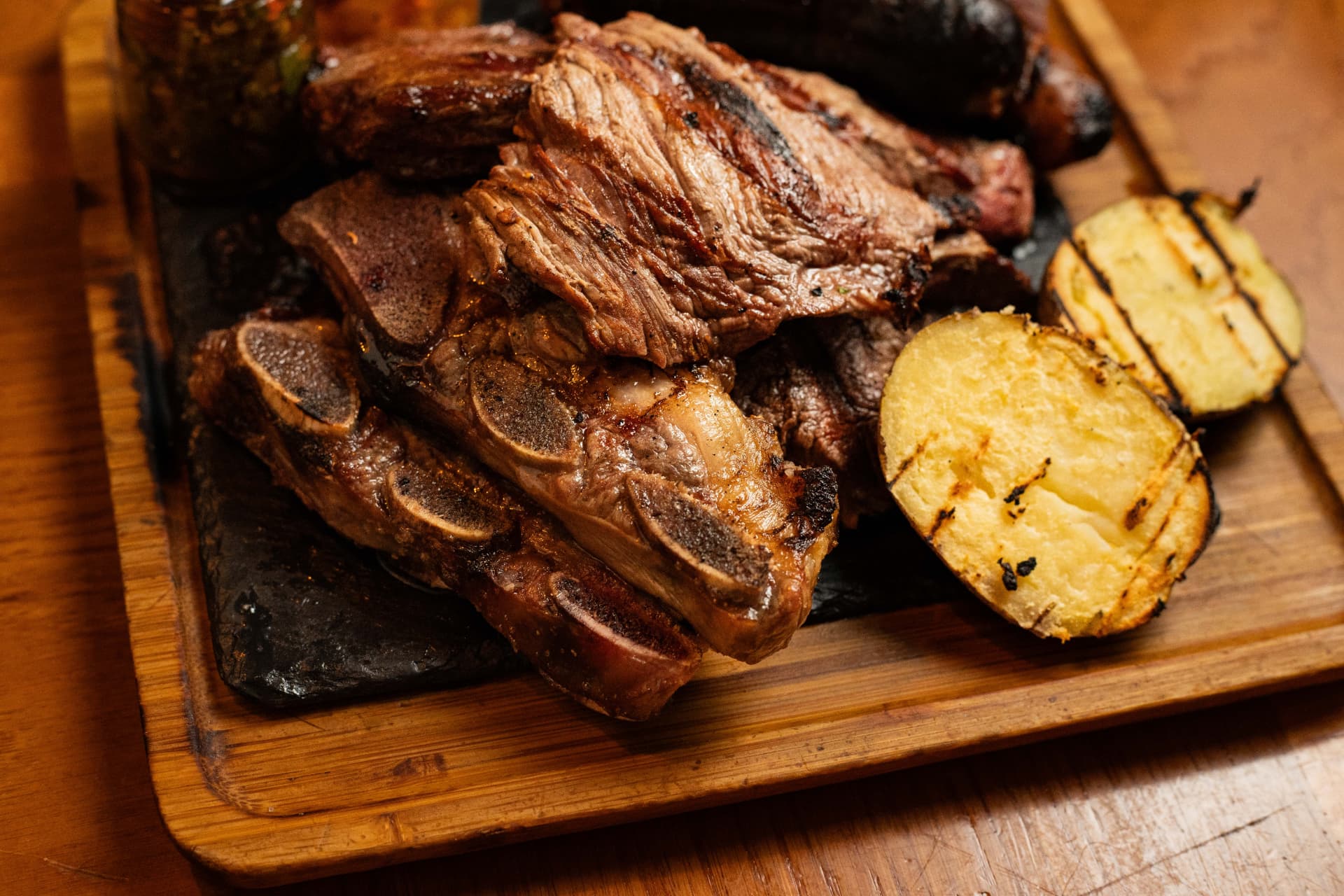 Costillar y patatas asadas en tabla de madera